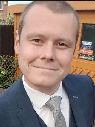 Chris Thame - white man wearing a light blue suit, white shirt and light grey tie.
