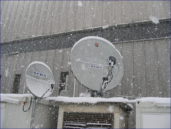 Two BFBS Satellite dishes in snowfall.