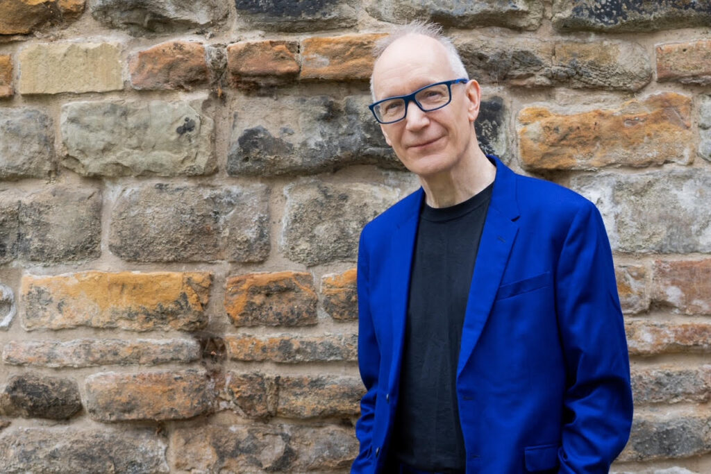 David Lloyd wearing electric blue suit and matching glasses.