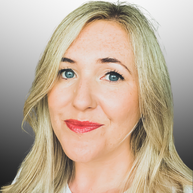 Emma is a white woman with long blonde hair and blue eyes. This is a headshot. She's smiling at us and has bright red lipstick. 